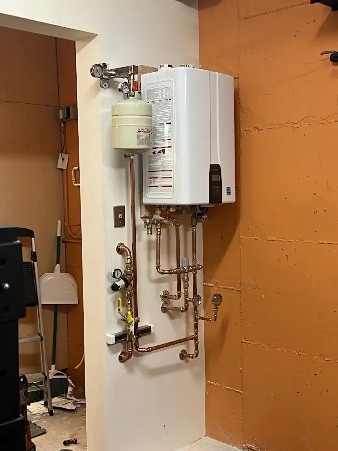 Plumbing technician inspecting water heater connections in Brecknock